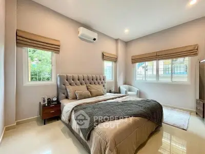 Spacious bedroom with elegant decor and natural light, featuring a plush bed and modern furnishings.