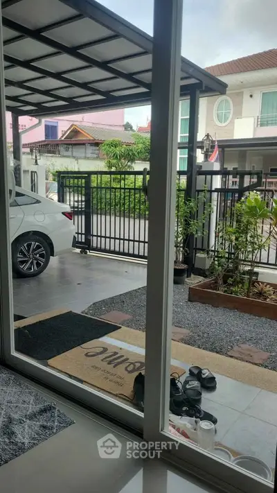 Modern home entrance with carport and garden view