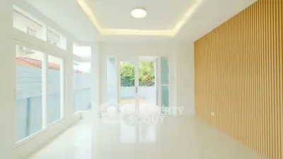 Spacious modern living room with large windows and stylish wood paneling