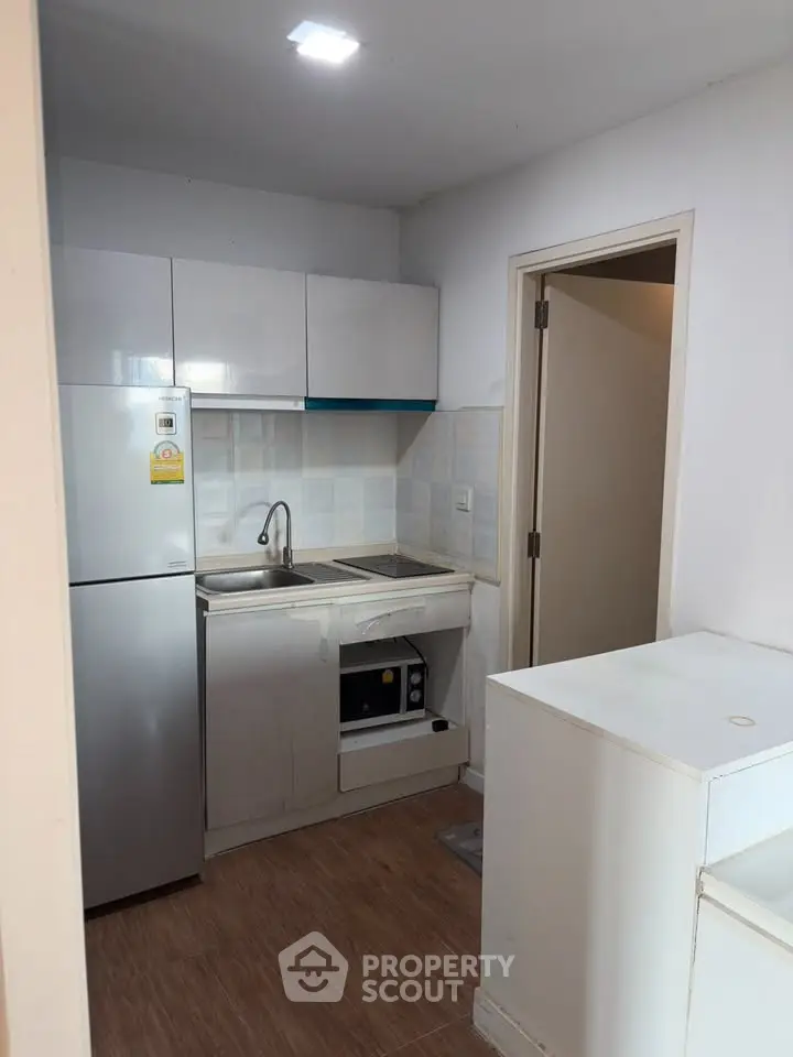 Compact modern kitchen with sleek appliances and minimalist design, perfect for urban living.