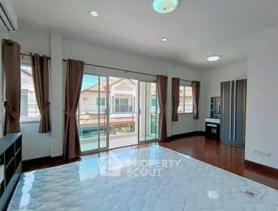 Spacious bedroom with large windows and balcony access in modern home