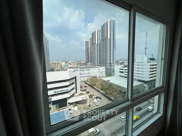 Stunning cityscape view from high-rise apartment window with modern buildings.