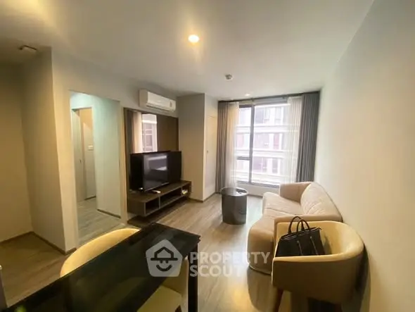 Modern living room with sleek furniture and large window for natural light.