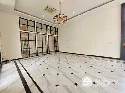 Spacious living room with elegant chandelier and modern tile flooring