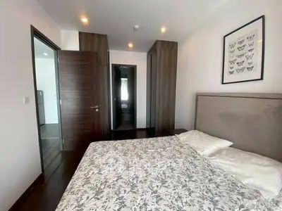 Modern bedroom with stylish decor and wooden accents in a contemporary apartment.