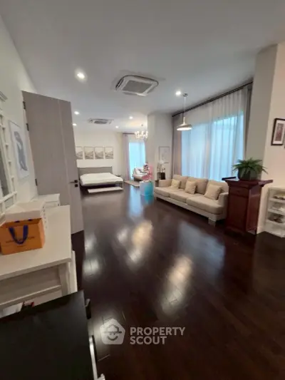 Spacious open-concept living room with elegant hardwood floors and cozy seating area.