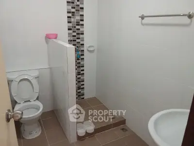 Modern bathroom with tiled shower and toilet in minimalist design