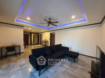 Spacious living room with modern ceiling design and cozy sectional sofa.