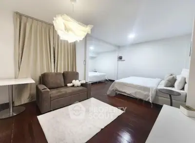 Spacious modern bedroom with elegant decor and cozy seating area