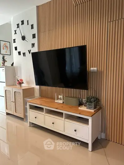 Modern living room with stylish wooden paneling and sleek TV setup