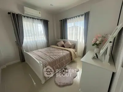 Cozy bedroom with elegant decor and natural light, featuring a comfortable bed and stylish curtains.