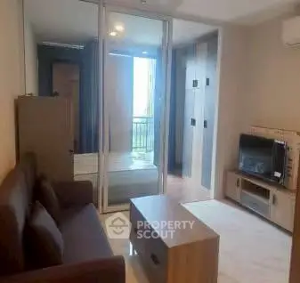 Modern living room with sleek furniture and glass partition in a cozy apartment.