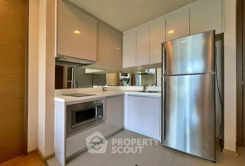 Modern kitchen with sleek cabinets and stainless steel appliances in a stylish apartment.