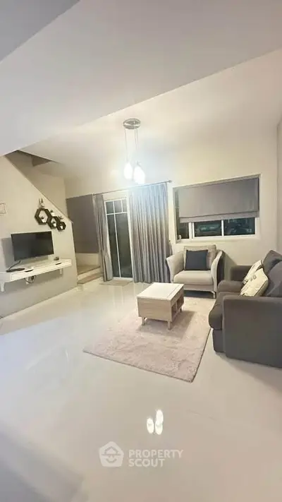 Modern living room with sleek furniture and ambient lighting, perfect for relaxation and entertainment.