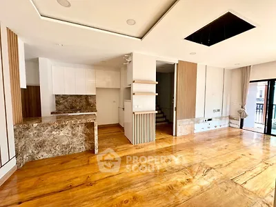 Spacious open-plan living area with modern kitchen and wooden flooring