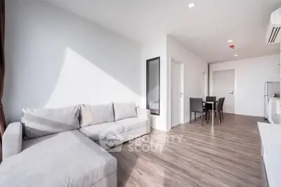 Spacious modern living room with sleek wooden flooring and cozy sectional sofa