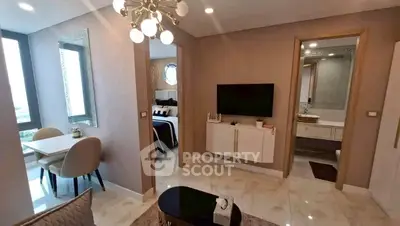 Modern apartment interior with open living area, dining space, and view into bedroom and bathroom.