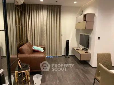 Modern living room with brown leather sofa and wall-mounted TV, featuring elegant decor and stylish furniture.