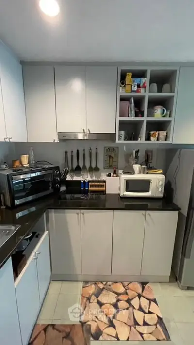 Modern kitchen with sleek cabinets, microwave, and oven, perfect for culinary enthusiasts.