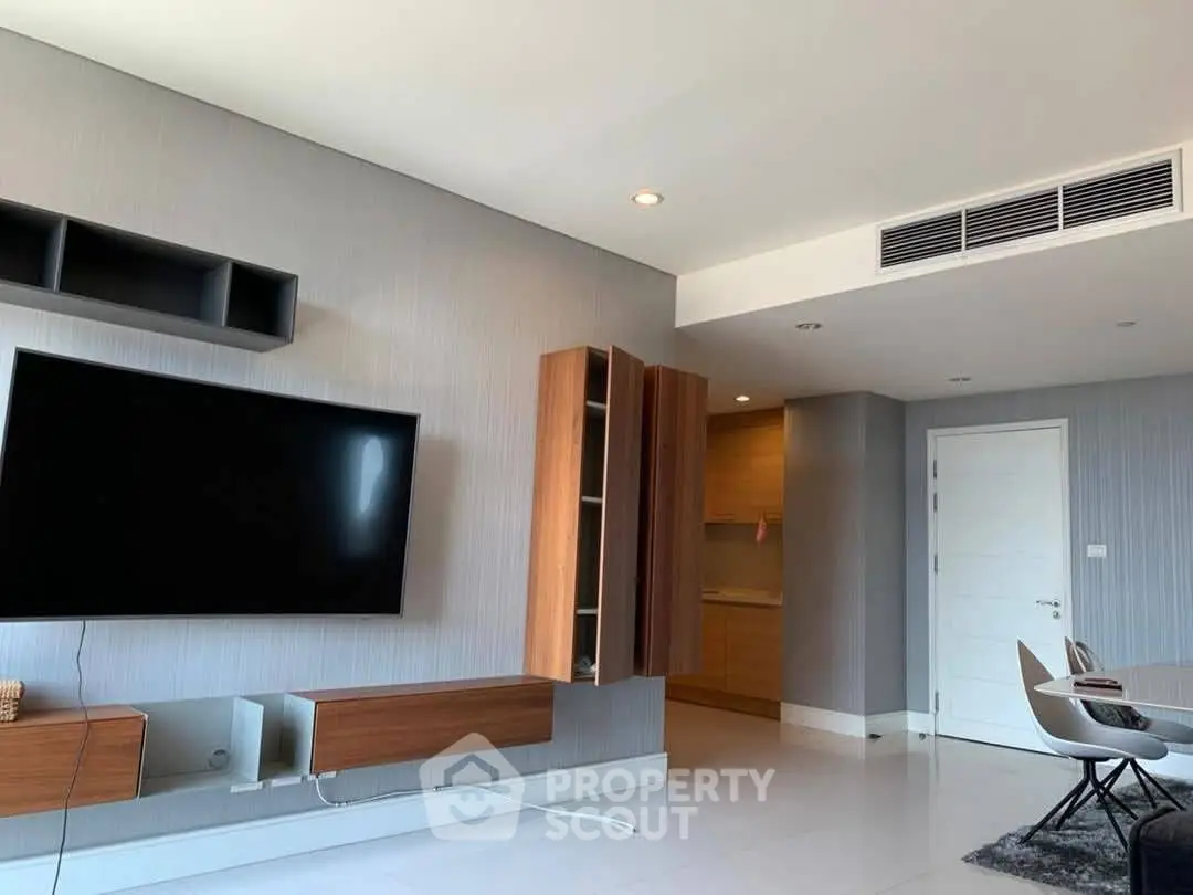 Modern living room with sleek furniture and large TV, perfect for entertainment.