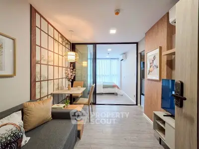 Modern open-plan living room with stylish decor and sliding glass doors leading to a cozy bedroom.