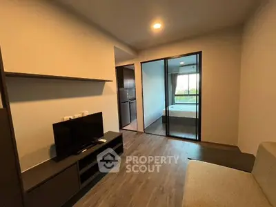 Modern living room with sleek design and glass partition to bedroom