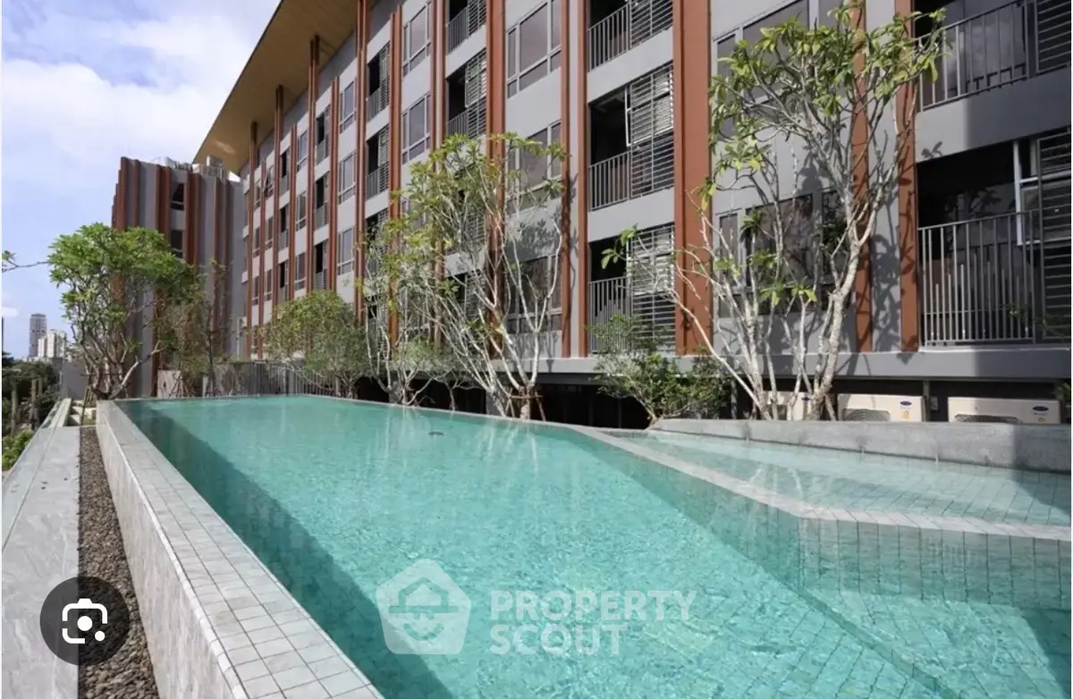 Luxurious apartment building with stunning pool and modern architecture.