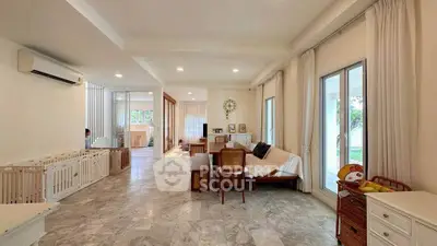 Spacious living room with marble flooring and large windows in a modern home