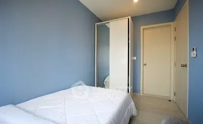 Cozy minimalist bedroom with blue walls and white furniture, perfect for a serene retreat.