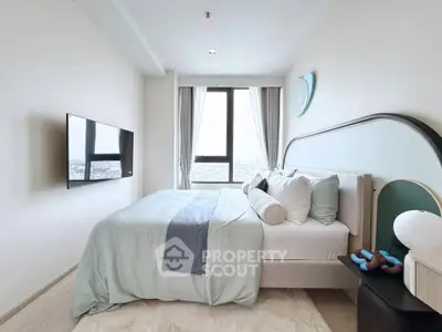 Modern bedroom with stylish decor and city view, featuring a wall-mounted TV and elegant bedding.