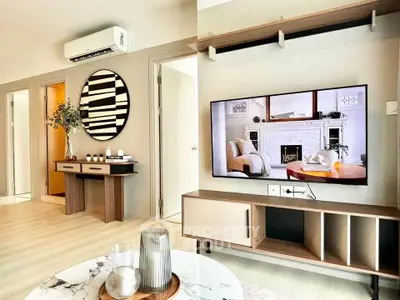 Modern living room with stylish decor and wall-mounted TV, featuring elegant furniture and neutral tones.