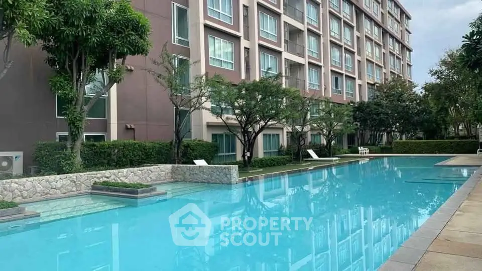 Luxurious residential building with a stunning outdoor pool and lush greenery.