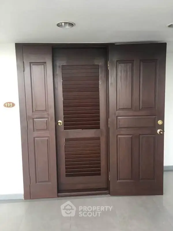 Elegant wooden apartment entrance door with modern design and sleek finish.