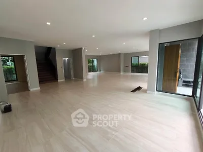 Spacious open-plan living room with modern design and large windows for natural light.