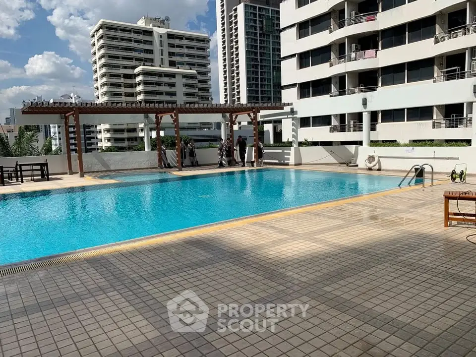 Luxurious rooftop pool with city views in a modern high-rise building.