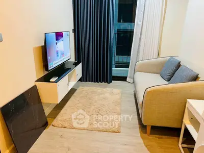 Cozy living room with modern decor and balcony access, featuring a comfortable sofa and mounted TV.