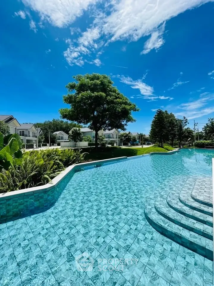 Luxurious outdoor pool with clear blue water and lush greenery in a serene residential area.