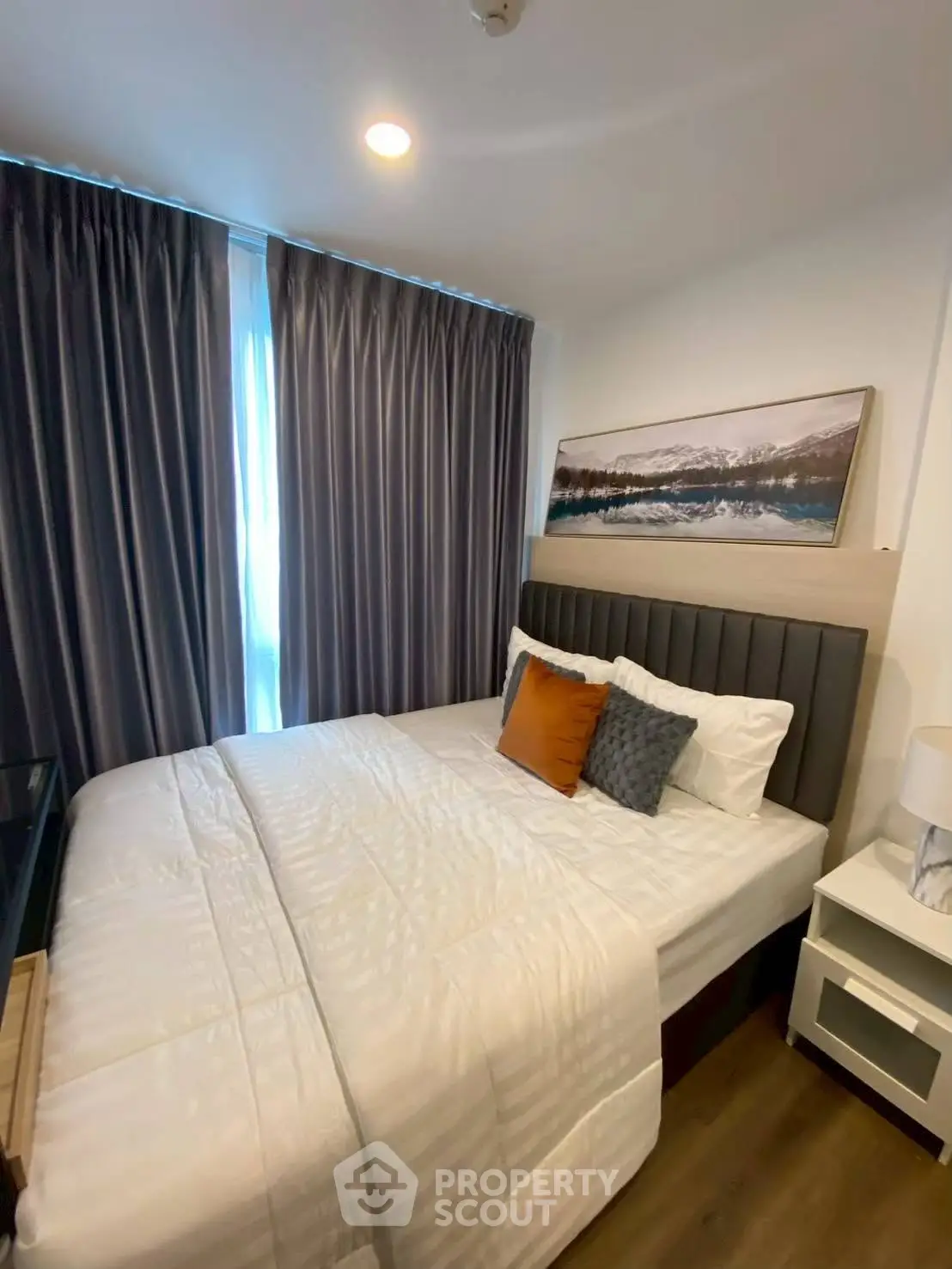 Cozy bedroom with modern decor and large window with curtains