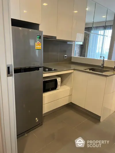 Modern kitchen with sleek cabinetry and stainless steel appliances in a contemporary apartment.