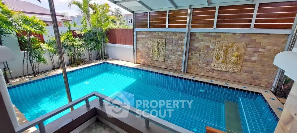 Luxurious private pool with elegant stone wall and tropical landscaping