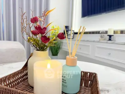 Elegant living room decor with candle and floral arrangement on marble table.