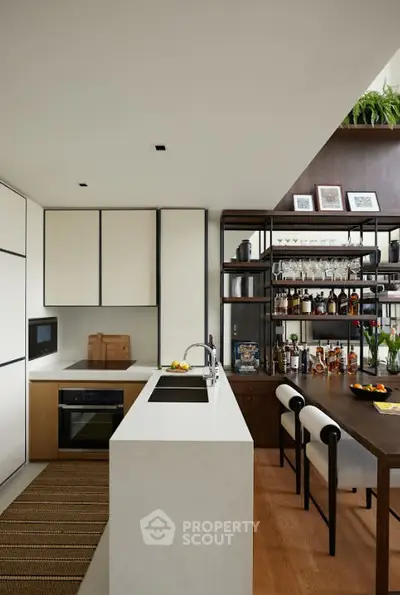 Modern kitchen with sleek cabinetry and stylish bar area, featuring an open layout and contemporary design.