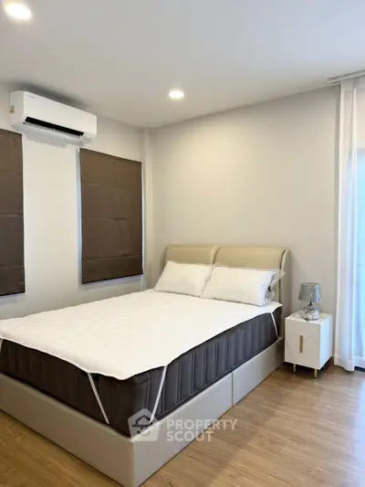 Modern bedroom with stylish decor and natural light, featuring a comfortable bed and elegant furnishings.