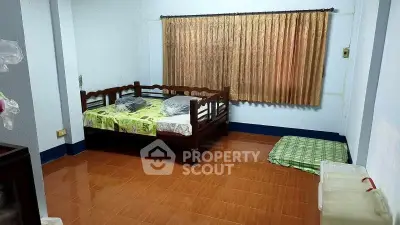 Cozy bedroom with wooden bed and tiled floor, perfect for a serene retreat.