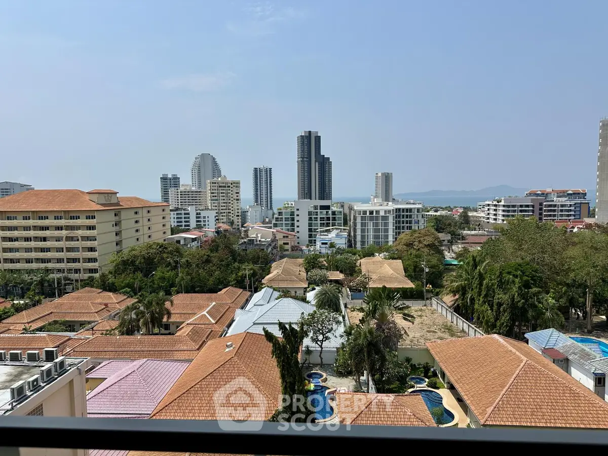 Stunning cityscape view from a high-rise balcony showcasing modern buildings and lush greenery.