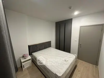 Modern bedroom with sleek design featuring a comfortable bed, stylish headboard, and ample closet space.