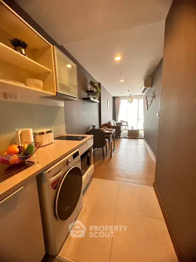 Modern open-layout kitchen with washing machine and cozy living area
