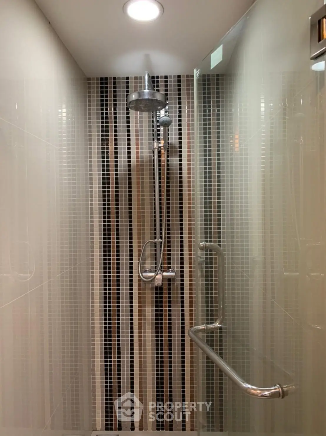 Modern bathroom shower with sleek tile design and stainless steel fixtures.