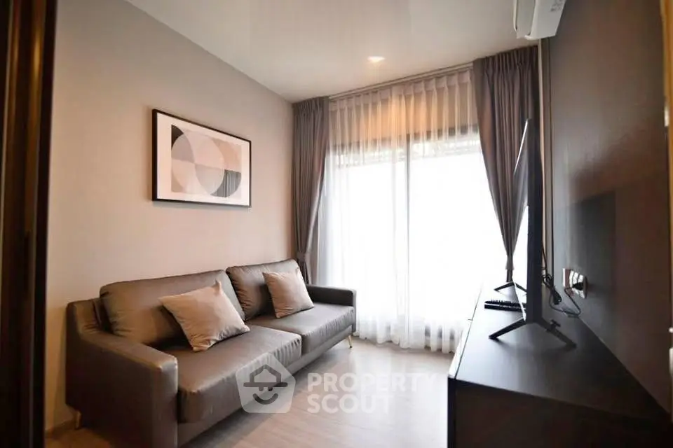 Modern living room with stylish sofa and large window in a cozy apartment.