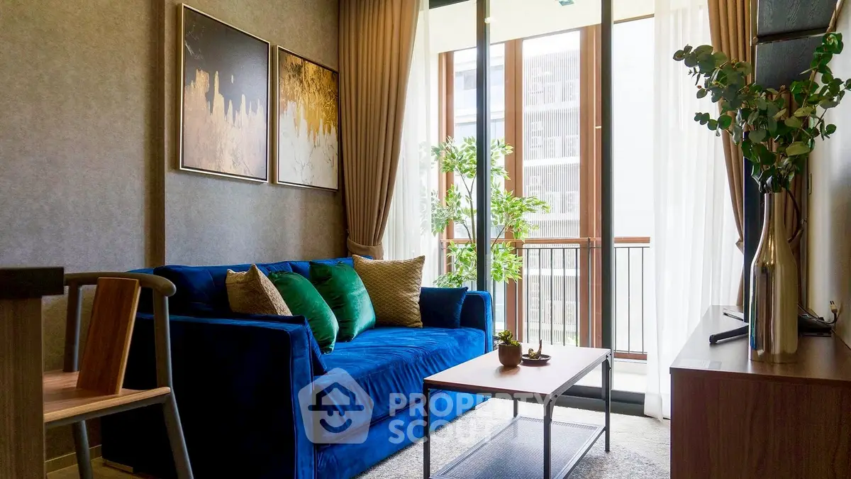 Stylish living room with blue sofa and large windows in modern apartment.